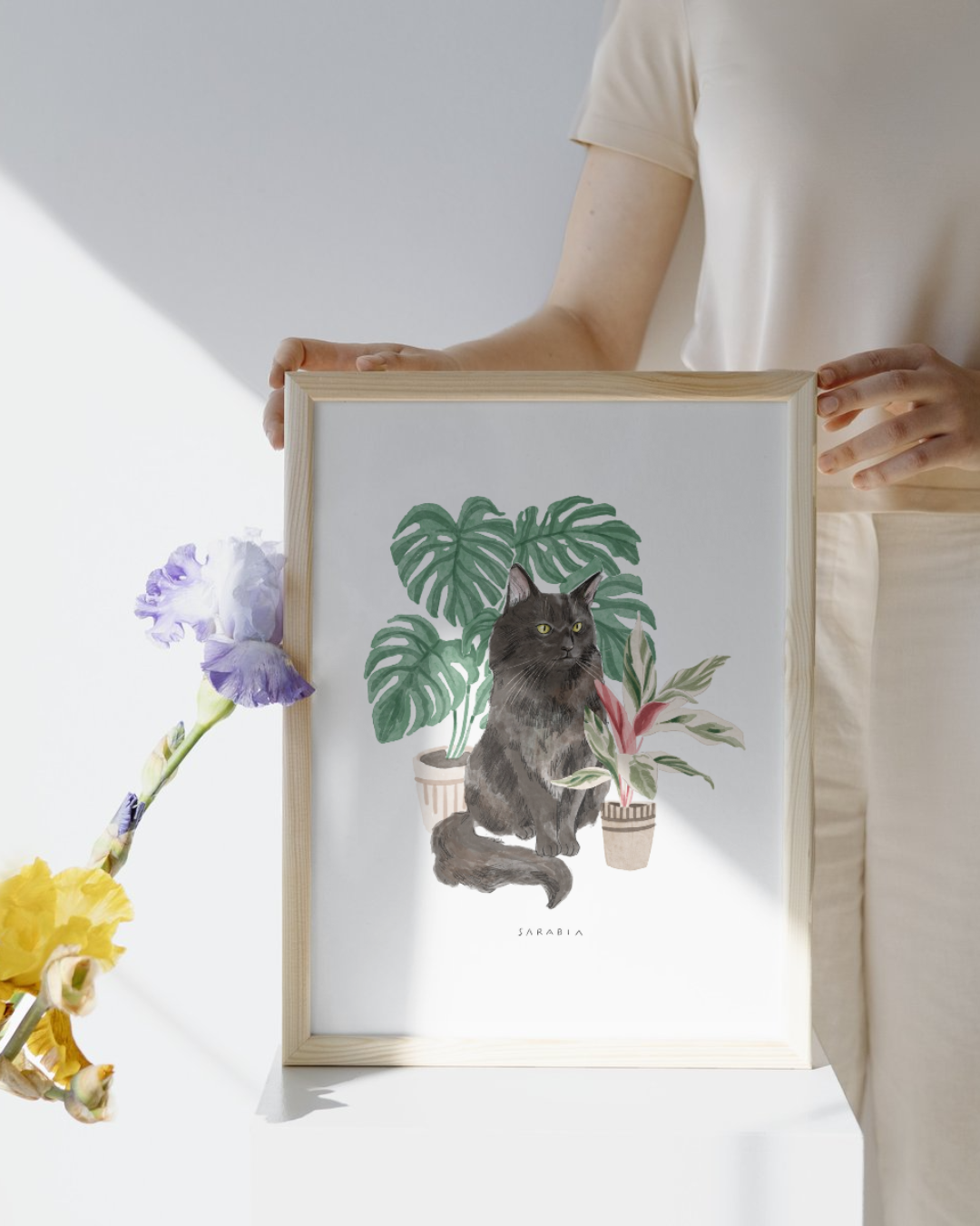 Lámina Gato negro peludo con planta monstera